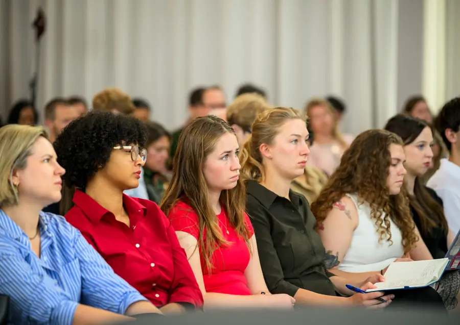 A row of attendees listening during one of the conversations.