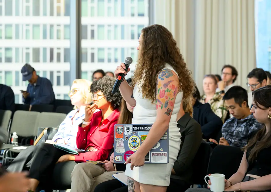 An attendee standing with a microphone to ask a question from the floor.