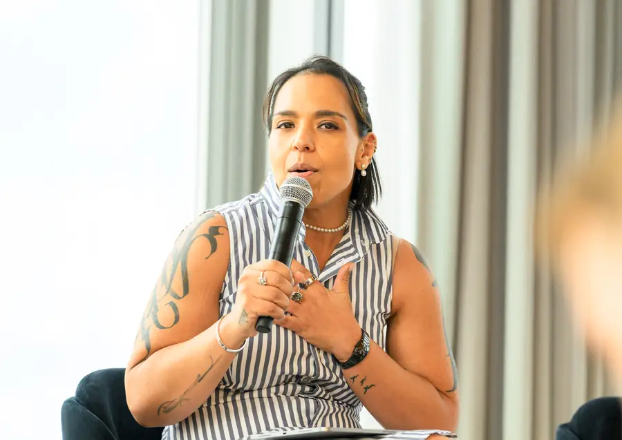 A speaker answering a question, microphone in hand.