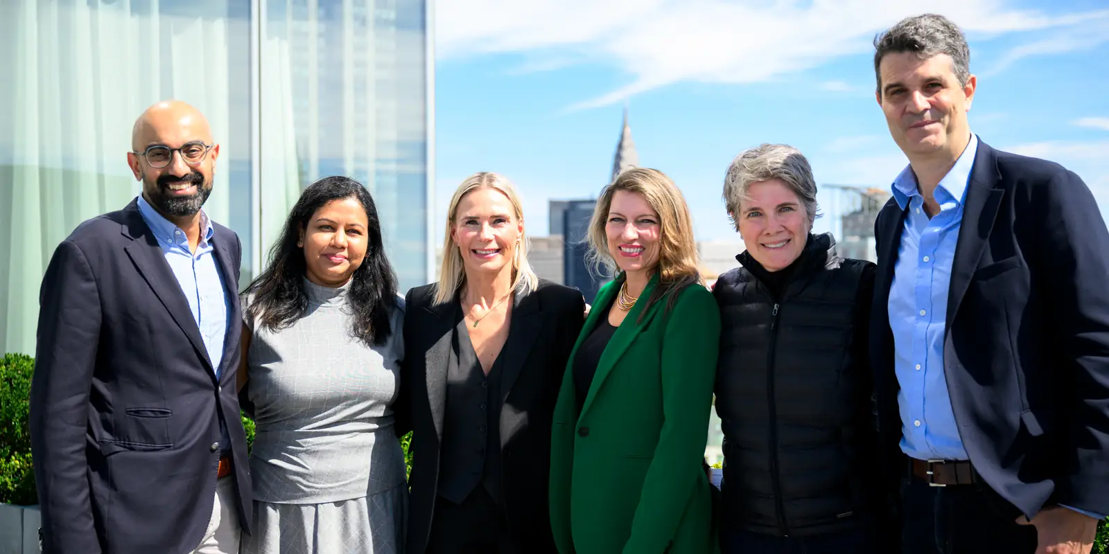 The speakers of Can Technology Make Us More Human? together on the terrace, with the Manhattan skyline behind them.